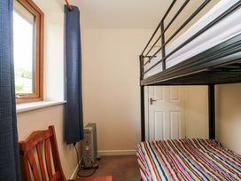 A bedroom with a bunk bed and chair at Orchard Cottage in Ledbury