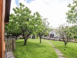 A garden with trees and a pathway at Orchard Cottage in Ledbury