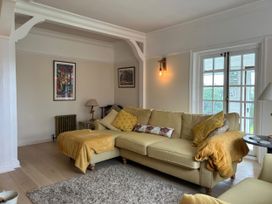 A living room with a yellow sofa and artwork on the wall at Somerby in St. Bees