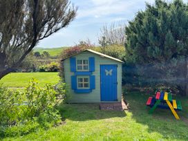 A garden with a playhouse and picnic table at Somerby in St. Bees