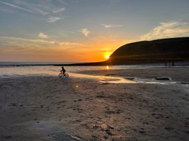 A boy riding a bicycle at sunset in St. Bees