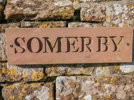 A nameplate reading 'SOMERBY' on a stone wall at Somerby St Bees