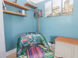 A living room with a chair and lamp at Somerby St Bees