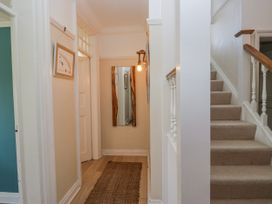 A hallway with a mirror and staircase at Somerby St Bees
