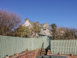 A house surrounded by a fence and trees at Somerby in St Bees