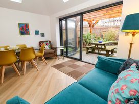 A living room with a dining area and patio doors at Still Waters in Weymouth