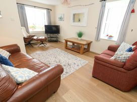 A living room with a sofa and television at Still Waters in Weymouth