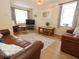 A living room with a coffee table and television at Still Waters in Weymouth