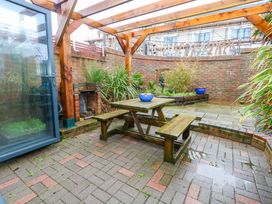 A garden with a table and benches at Still Waters in Weymouth