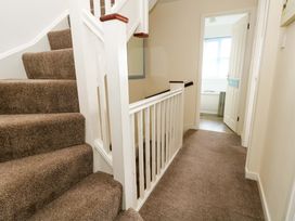 A hallway with stairs and a door leading to a bathroom at Still Waters in Weymouth