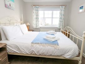 A bedroom with a bed and towels on it at Still Waters in Weymouth