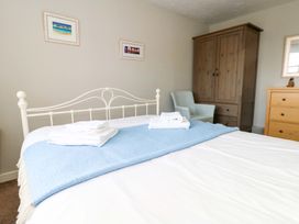 A bedroom featuring a bed, dresser, armoire, and chair at Still Waters in Weymouth