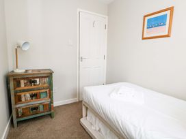 A bedroom with a single bed and a lamp at Still Waters in Weymouth