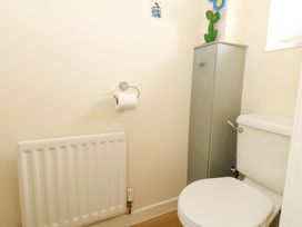 A bathroom with a toilet and storage cabinet at Still Waters in Weymouth