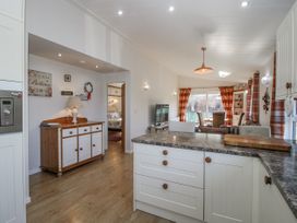 A kitchen with a console table and television at Hazel Lodge Clunton near Clun