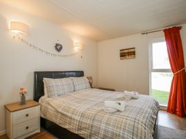 A bedroom with a bed and nightstand at Hazel Lodge in Clunton near Clun