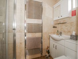 A bathroom with a towel radiator and sink at Hazel Lodge Clunton near Clun