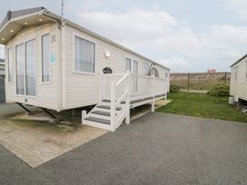 A caravan with steps on grass at 11, Beachfields