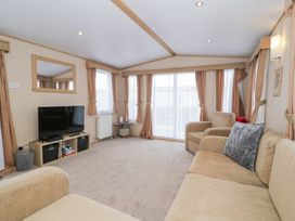 A living room with a television and sofa at 11, Beachfields