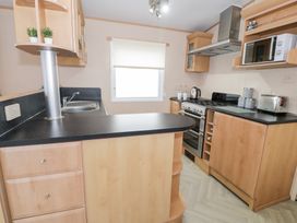 A kitchen with sink, stove, and appliances at 11, Beachfields