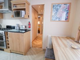 A kitchen with appliances and table at 11, Beachfields