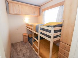 A bedroom with bunk beds and a bedside table at 11, Beachfields