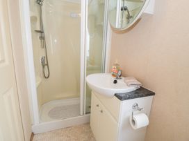 A bathroom with a shower and sink at 11, Beachfields