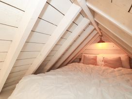 An attic with a bed and a light fixture at Shades Farm Cabin in Cirencester