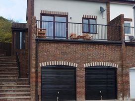A house with a balcony and garages at Upper Longlands Dawlish