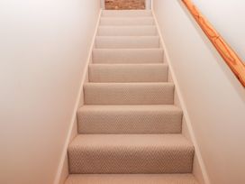 Staircase with carpet and a handrail at Garden Cottage at the Bowden Estate Stoke Fleming