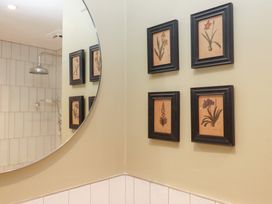 A bathroom with framed art on the wall at Garden Cottage at the Bowden Estate Stoke Fleming