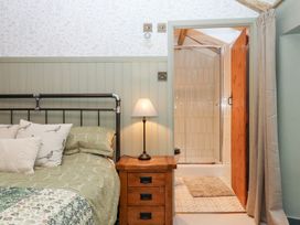 A bedroom with a bed and shower at Garden Cottage at the Bowden Estate Stoke Fleming