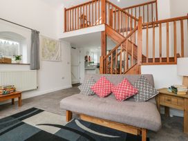 A living room with a sofa and stairs at Horse Gin in Lydney