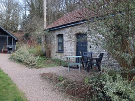 An outdoor area with a stone building and seating at Horse Gin in Parkend