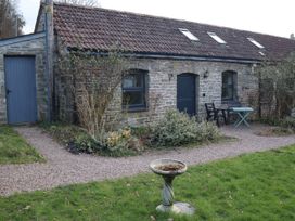 A stone building with a table and chairs outside at Horse Gin in Parkend