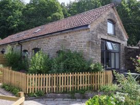 An outdoor view of a stone building with a fence at Horse Gin in Parkend