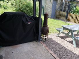A garden with a barbecue grill and picnic table at Horse Gin in Parkend
