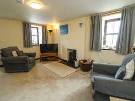 A living room with a sofa and television at Getws in Ty Croes