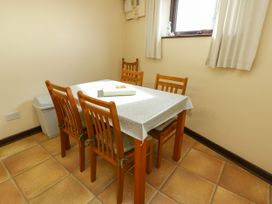 A dining room with a table and four chairs at Getws in Ty Croes