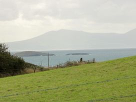 A view of islands in the sea with a mountain in the background at Getws, Ty Croes