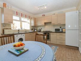 A kitchen with wooden cabinets and a dining table at 15 Rose Hill Beaumaris