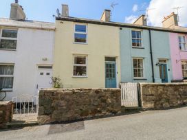 A row of colorful cottages with a stone wall at 15 Rose Hill Beaumaris
