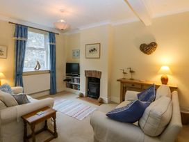 A living room with a sofa, fireplace and television at 15 Rose Hill Beaumaris