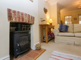 A living room with a wood stove and sofa at 15 Rose Hill Beaumaris