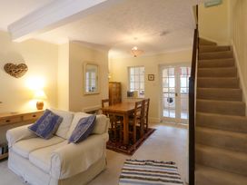 A living room with a dining table and staircase at 15 Rose Hill Beaumaris