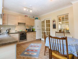 A kitchen with cabinets and a dining table at 15 Rose Hill Beaumaris