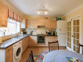 A kitchen with cabinets, appliances and dining table at 15 Rose Hill Beaumaris
