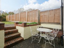A garden with steps leading to a seating area with a table and chairs at 15 Rose Hill Beaumaris