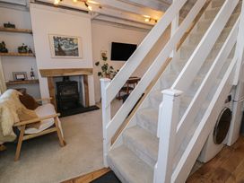 A living room with a staircase and a fireplace at Lon Popty in Dolgellau