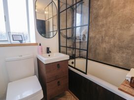 A bathroom with a toilet and bathtub at Lon Popty in Dolgellau